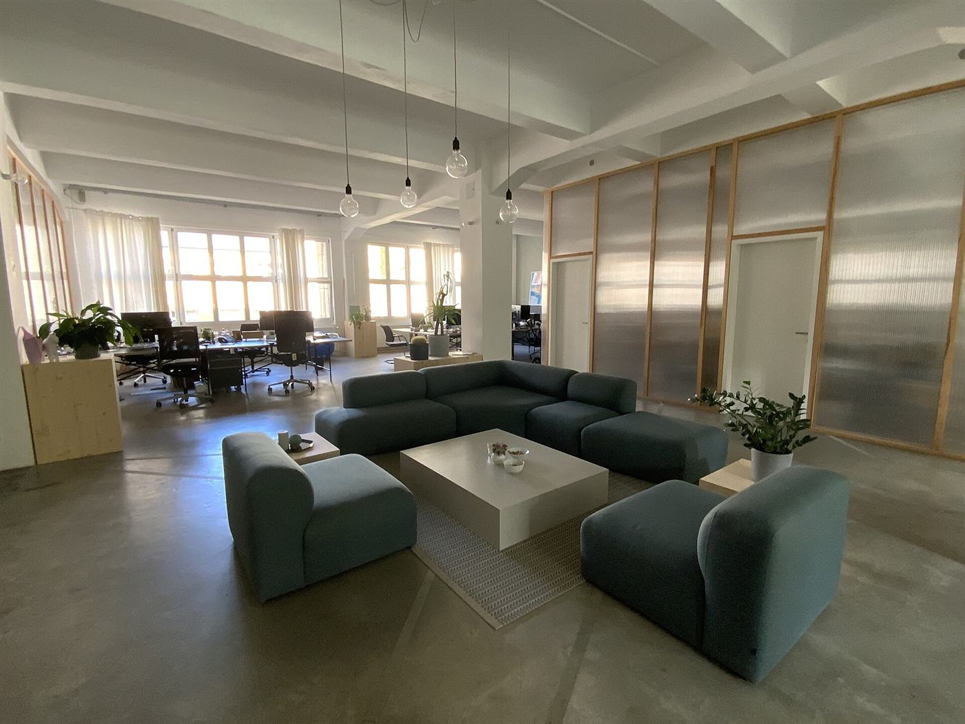 Sofas and a low table in the lounge area of an open-plan workspace